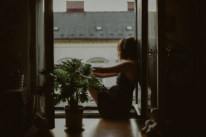 Woman leaning on door looking outside